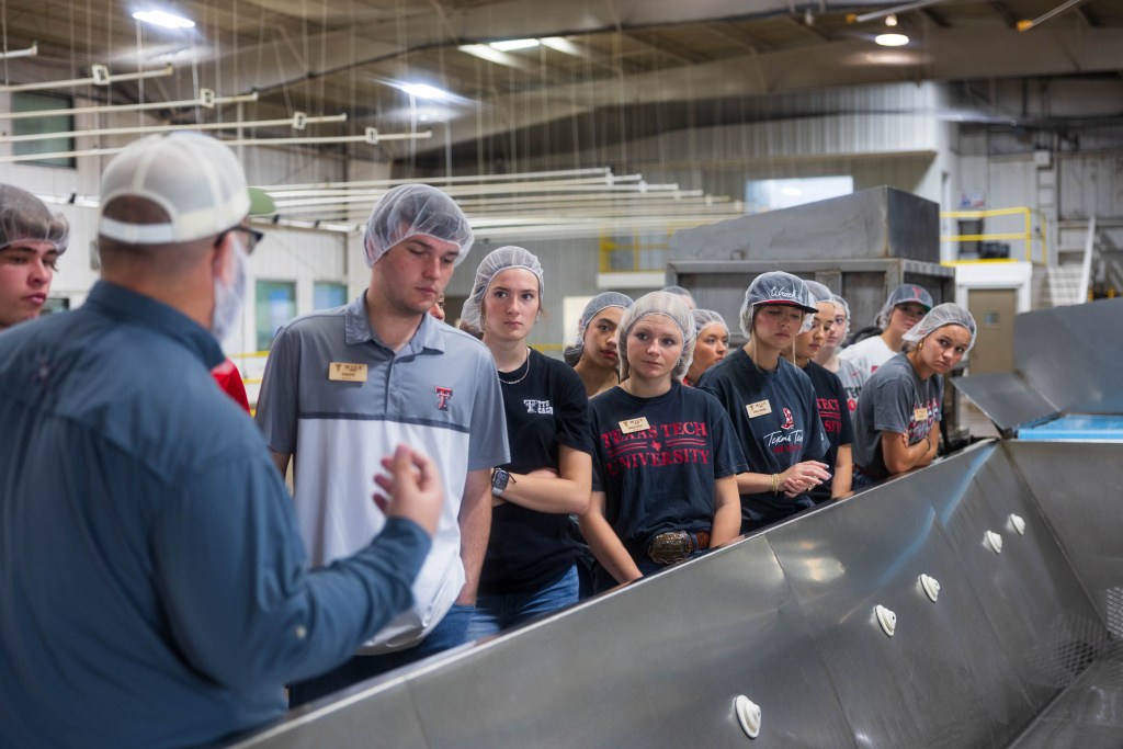 Students from the Matador Institute of Leadership Engagement listening to a presentation during a tour of an agricultural facility in Texas.