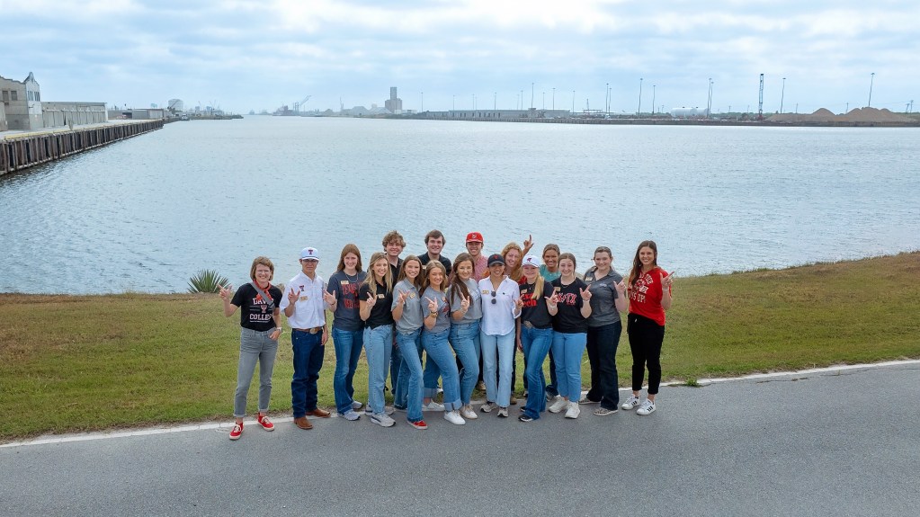 A group of students from the Matador Institute of Leadership Engagement poses for a photo near the waterfront in Texas' Rio Grande Valley during their agriculture tour.