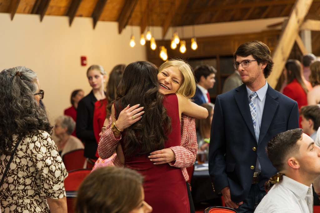 Graduates embracing each other during the MILE Program graduation ceremony at Texas Tech University, held in the Dairy Barn facility.